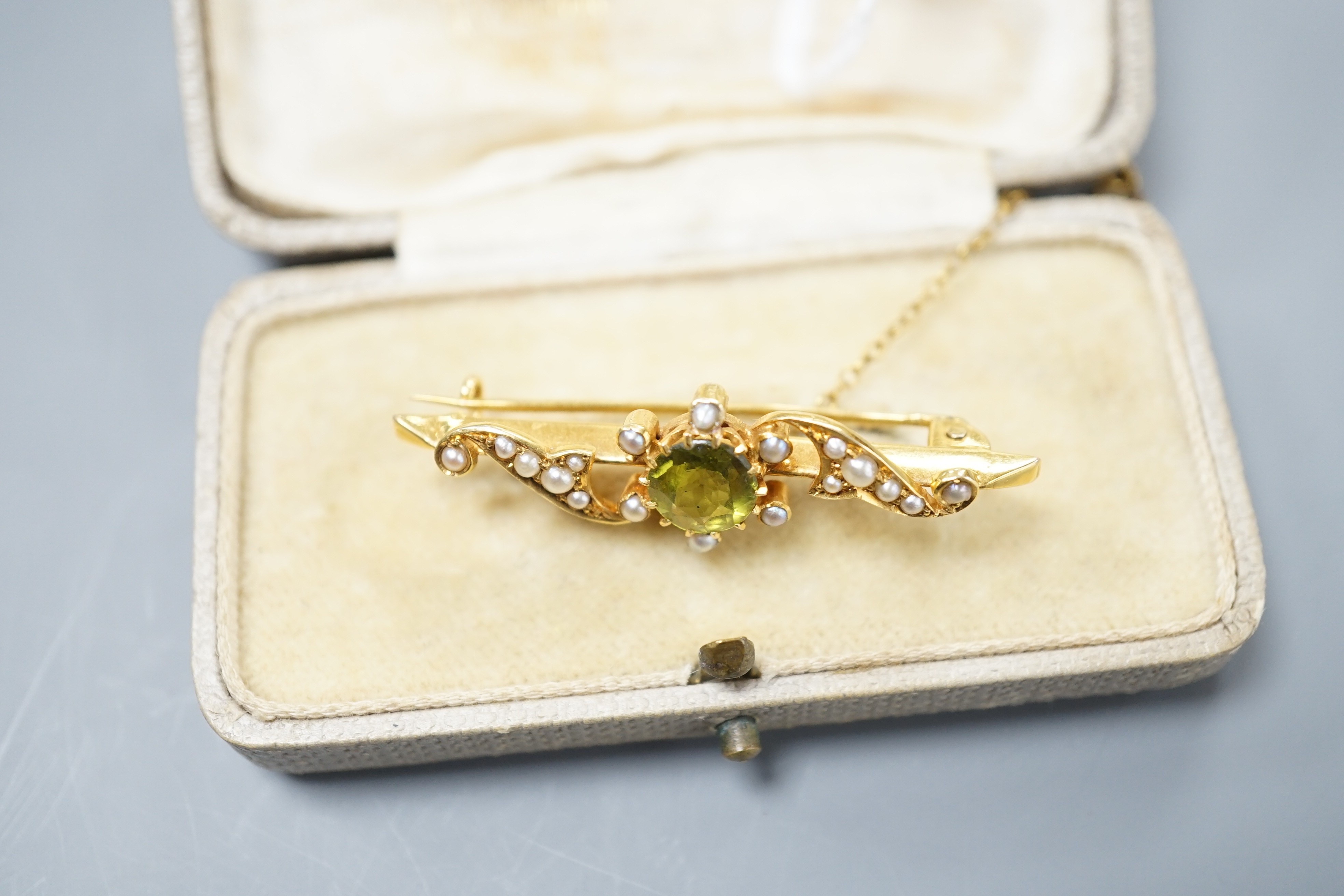 An Edwardian 15ct, peridot and seed pearl set bar brooch, 43mm, gross weight 4.2 grams.